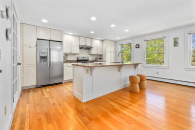 Bright and airy kitchen and dining space in Hanover NH home for sale, featuring modern finishes and access to a spacious back deck