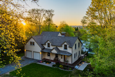 Charming 1949 New Englander home for sale in Hanover NH with white clapboard siding, welcoming front porch, and landscaped front yard