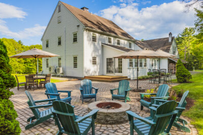 Beautifully crafted paver patio with fire pit on landscaped grounds in Quechee Colonial home